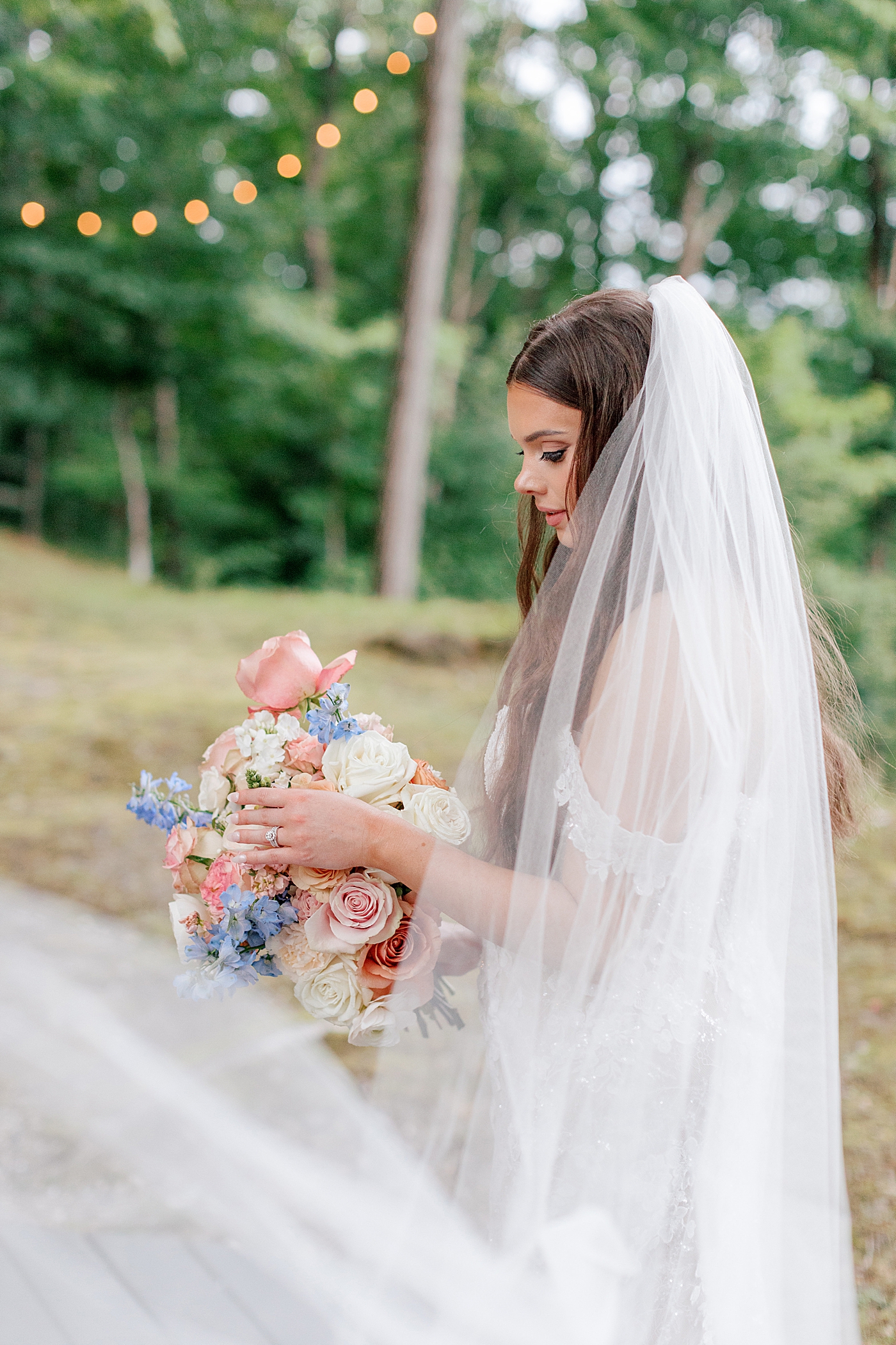Bride adjusting her bouquet during Promise Ridge Wedding | Image by Hope Helmuth Photography 
