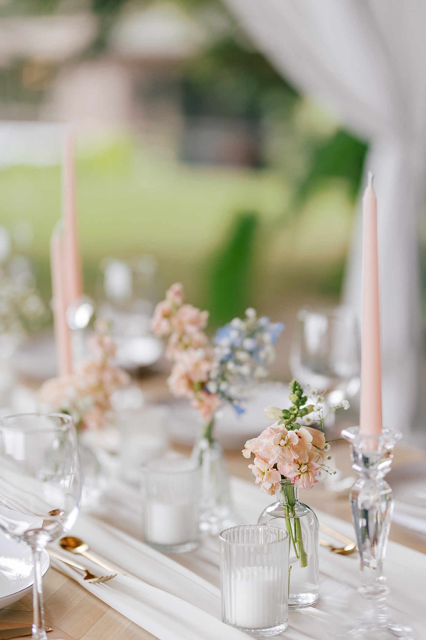 Wedding reception table with pink tapered flowers during Promise Ridge Wedding | Image by Hope Helmuth Photography 