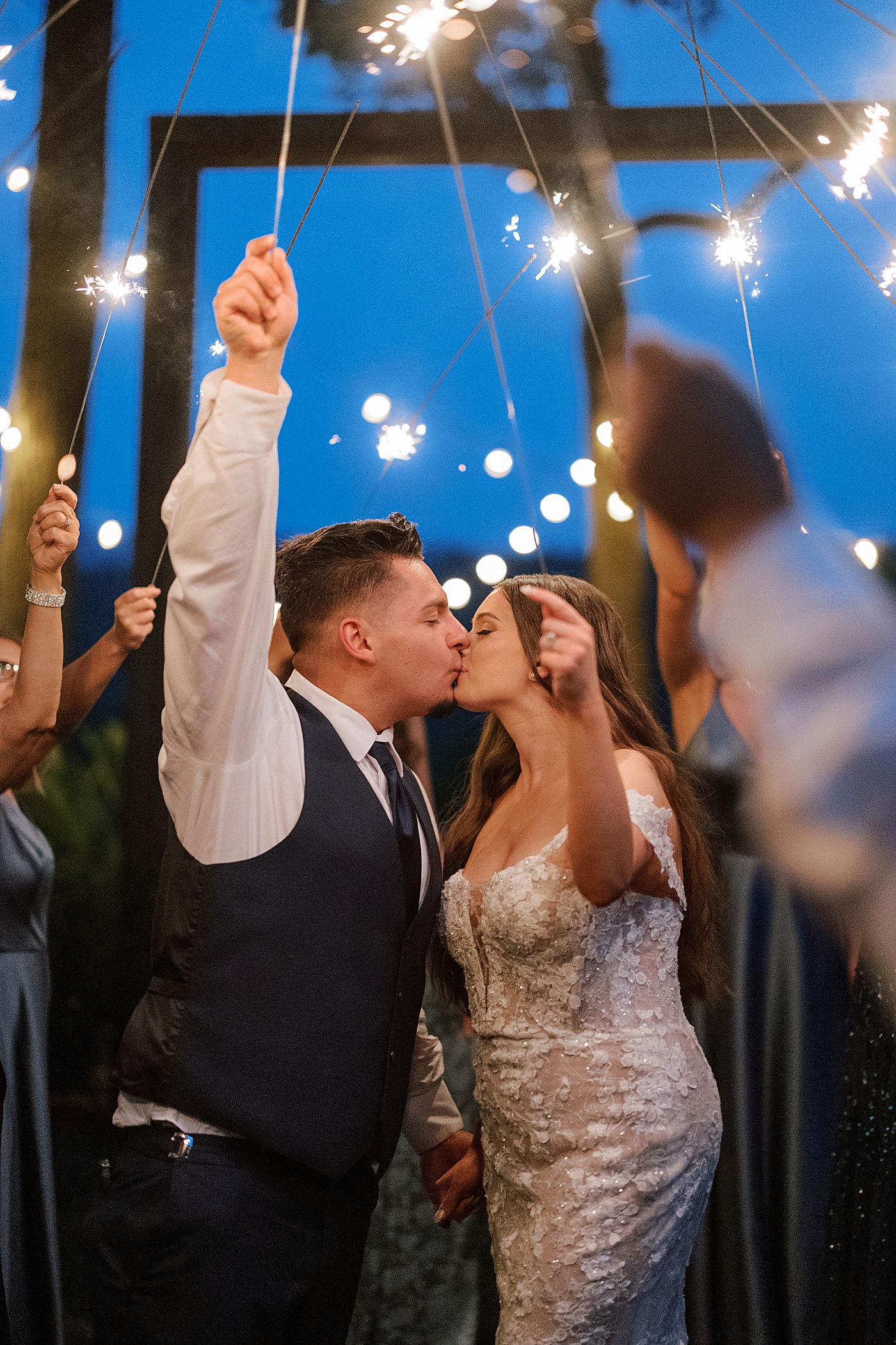 Bride and groom kiss holding sparkler during exit | Image by Hope Helmuth Photography 