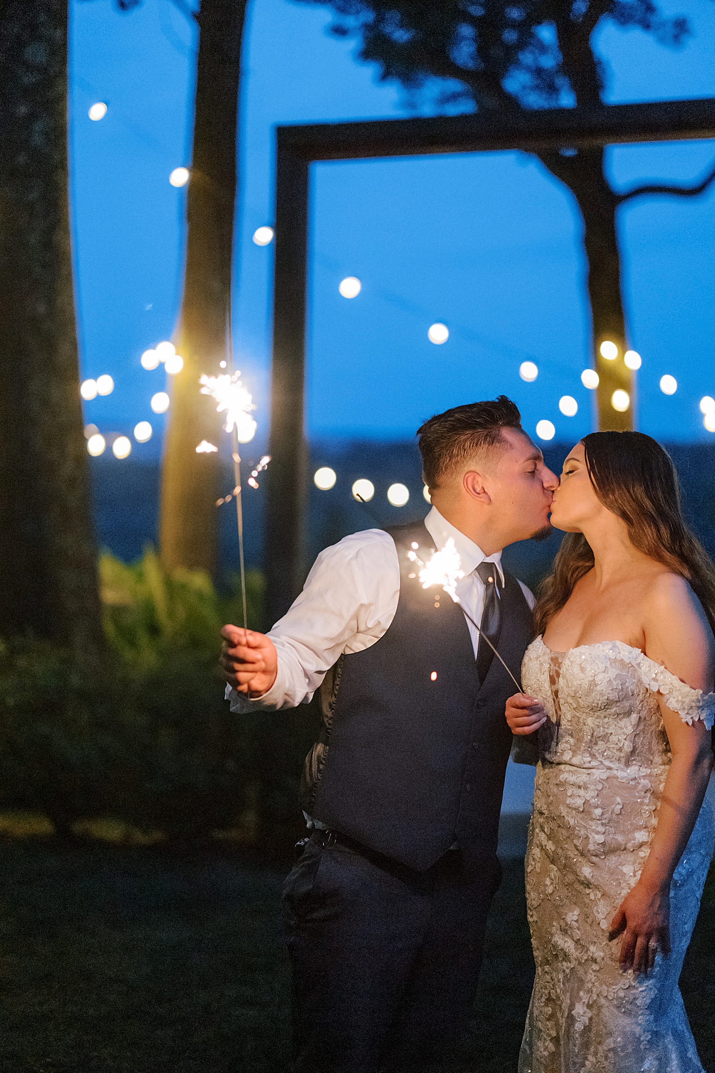 Bride and groom kissing holding sparklers during Promise Ridge Wedding | Image by Hope Helmuth Photography 