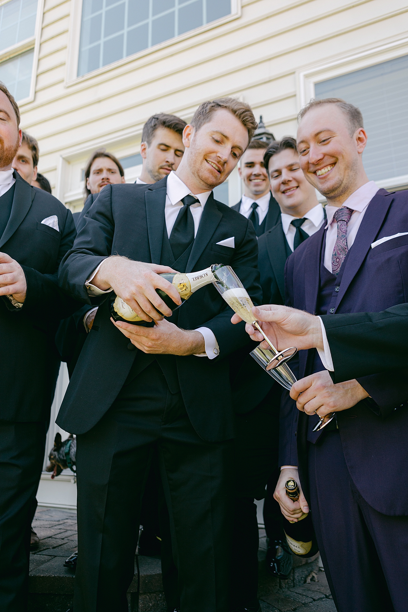 Groom pouring champagne with groomsmen during Tyler Gardens Wedding| Image by Hope Helmuth Photography