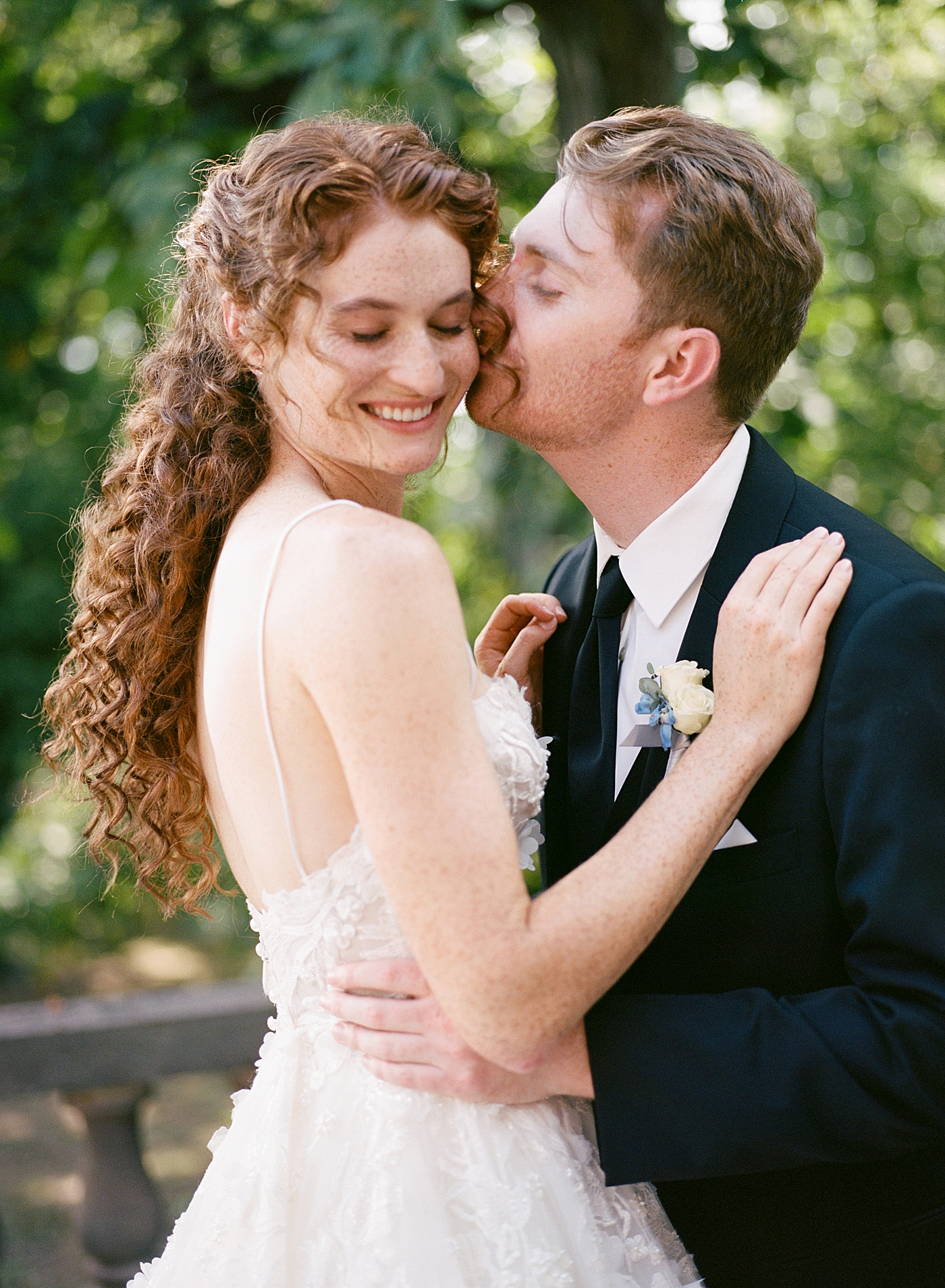 Close up of groom kissing the bride on her cheek during Tyler Gardens Wedding | Image by Hope Helmuth Photography