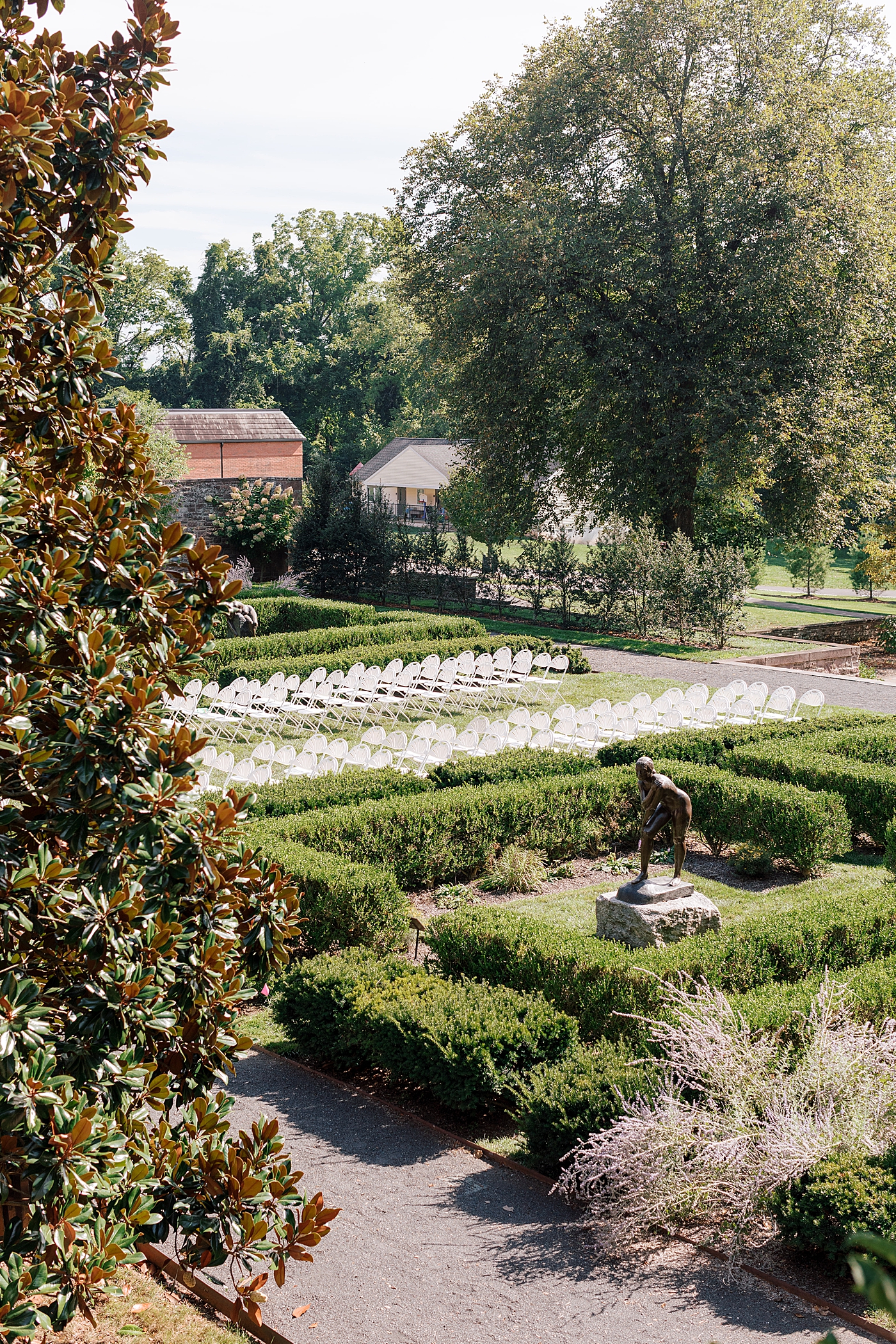 Landscape location image of ceremony site in a garden with statues and fountains during Tyler Gardens Wedding | Image by Hope Helmuth Photography