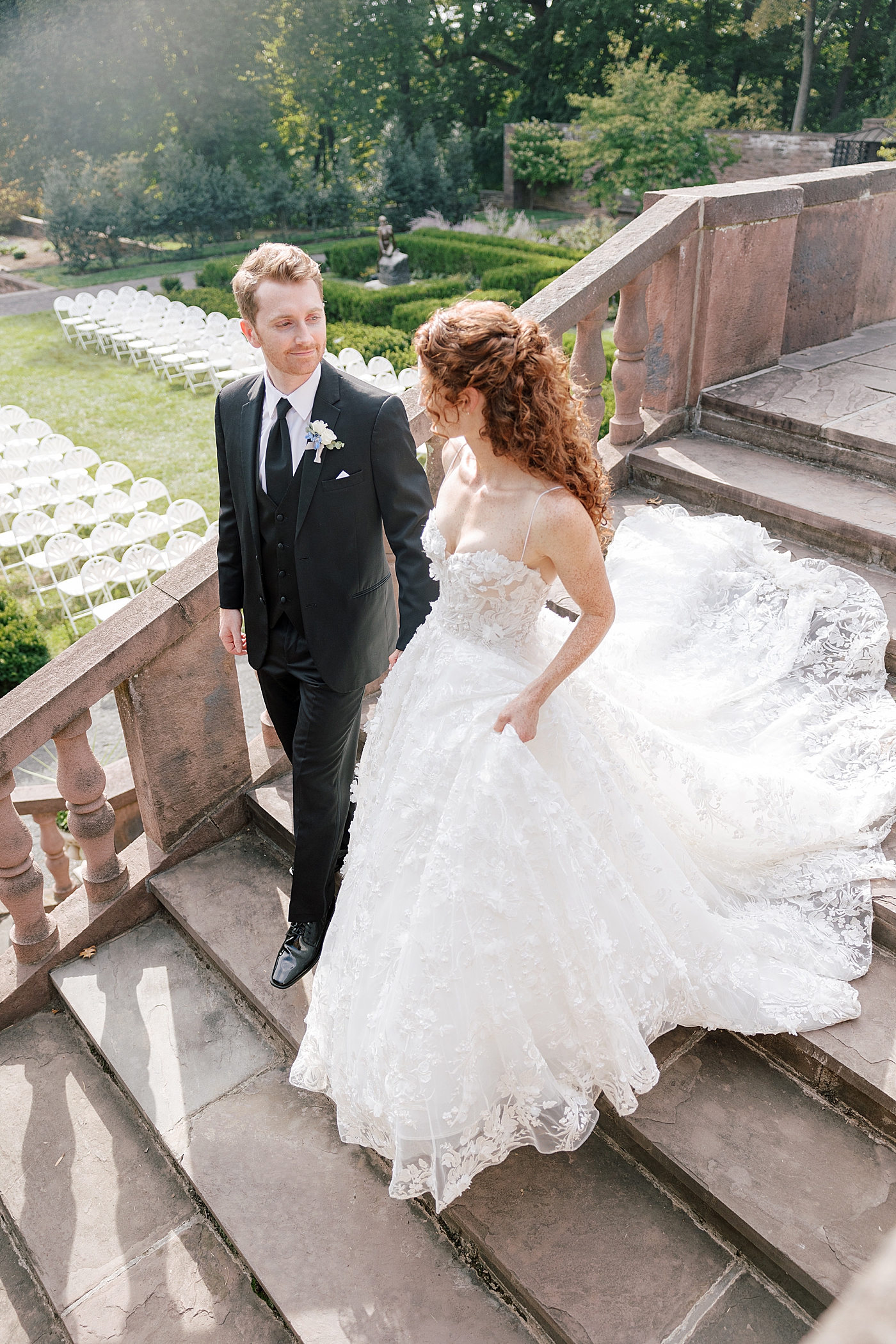Bride and groom walking down chateau steps during Tyler Gardens Wedding | Image by Hope Helmuth Photography