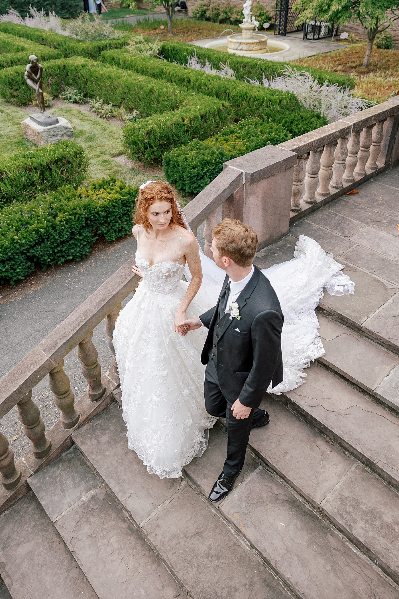 Bride and groom walking down steps of a garden during Tyler Gardens Wedding | Image by Hope Helmuth Photography