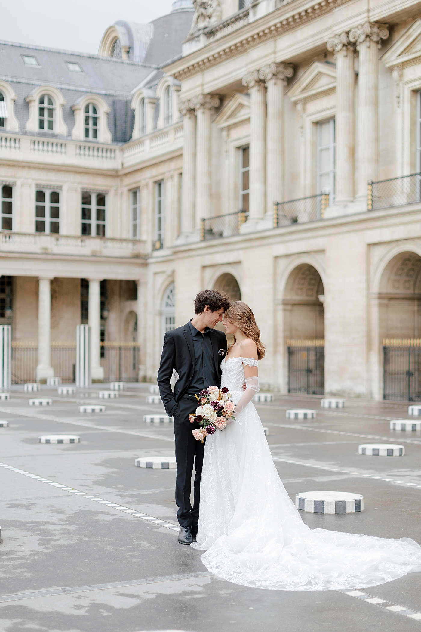 Image of a bride and groom embracing, foreheads together, with a European chateau in the background | Image by Hope Helmuth Photography