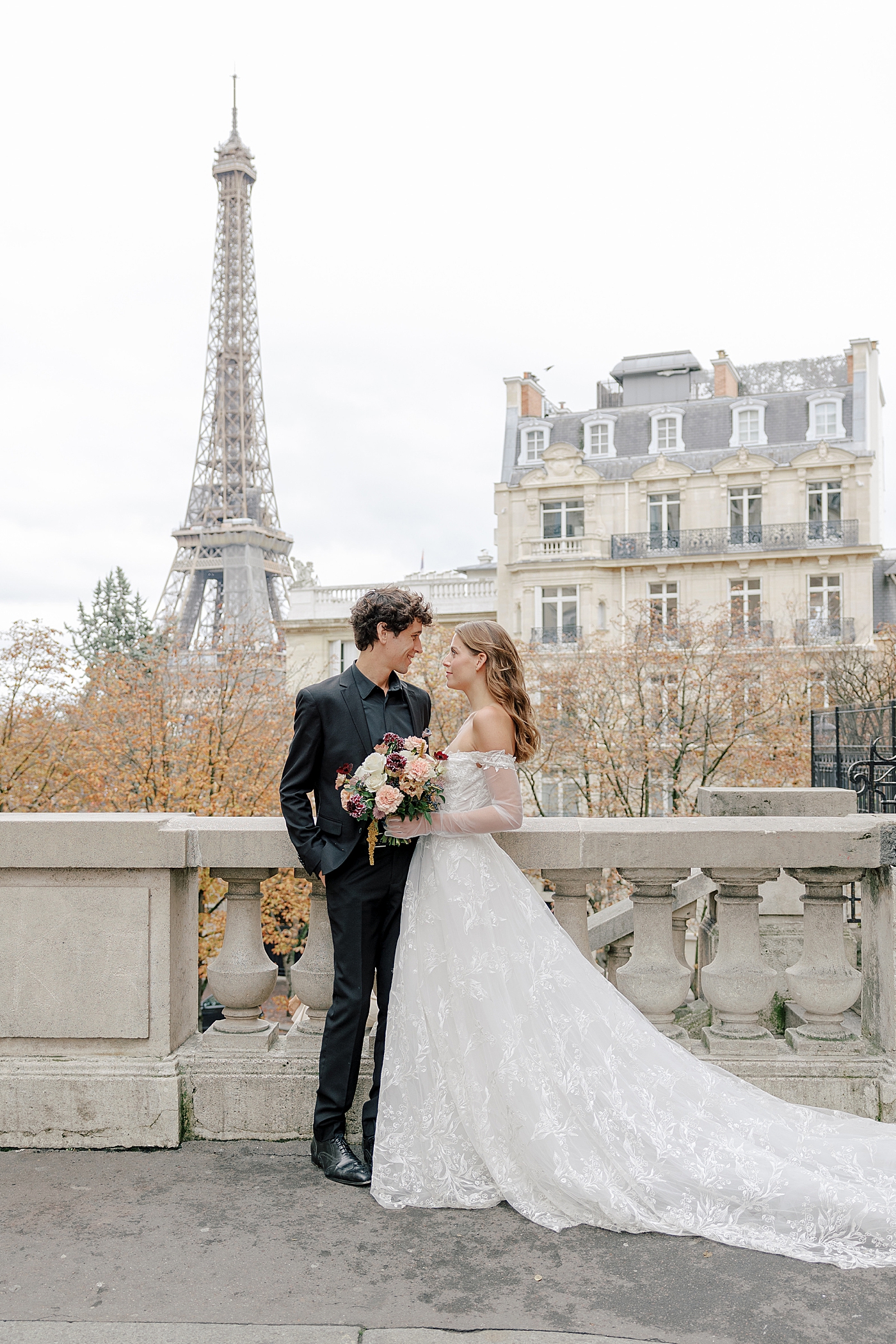 Bride and groom embracing with the Eiffel Tower in background | Image by Hope Helmuth Photography