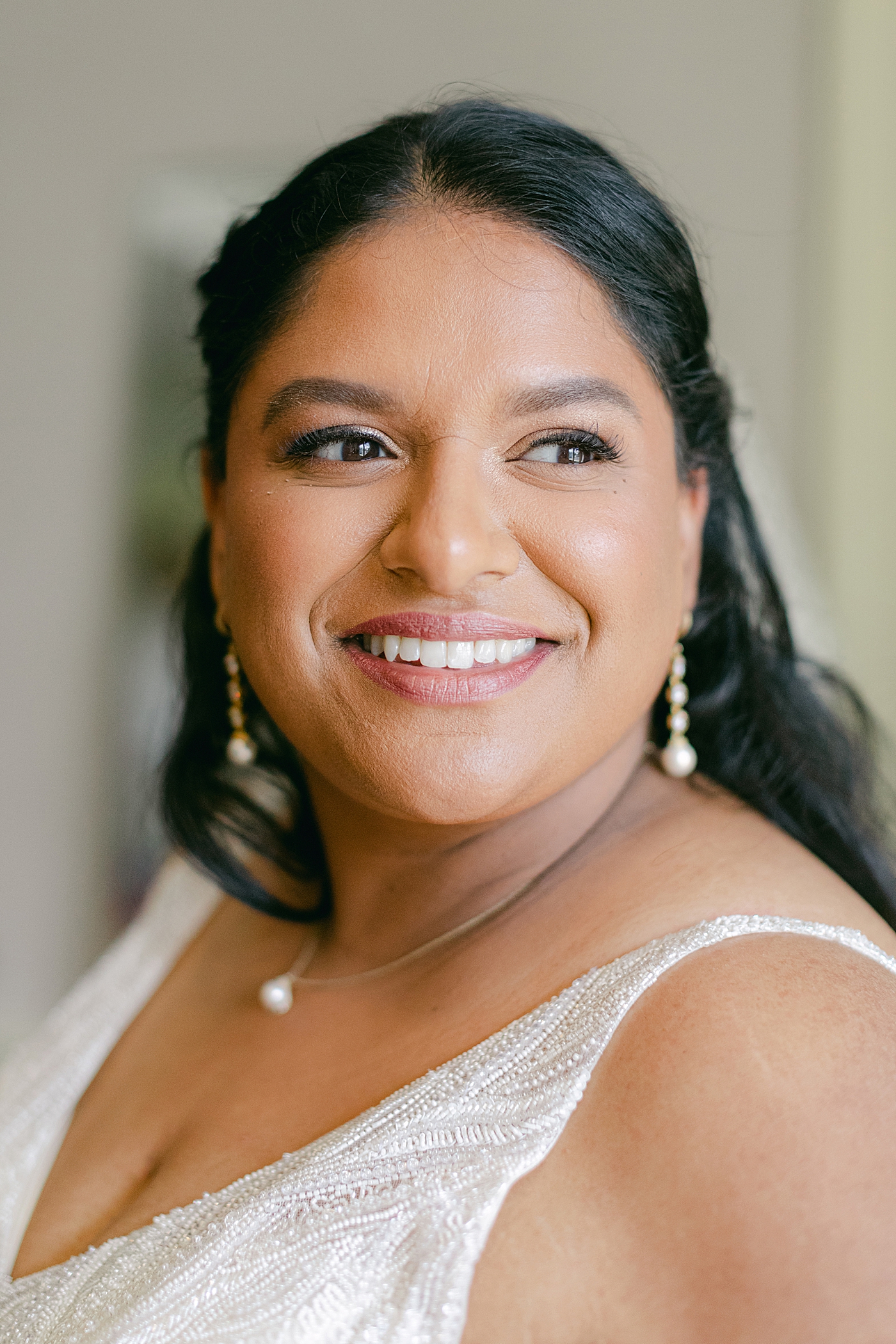 Close up image of a bride smiling after getting her hair and make up done | Image by Hope Helmuth Photography
