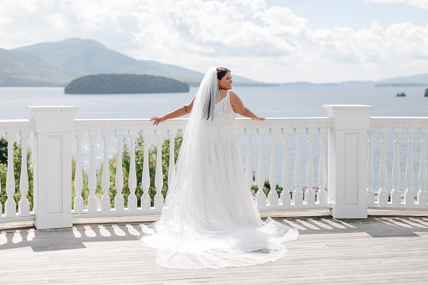 Back of dress details of a bride on a deck in full sun with white railings | Image by Hope Helmuth Photography