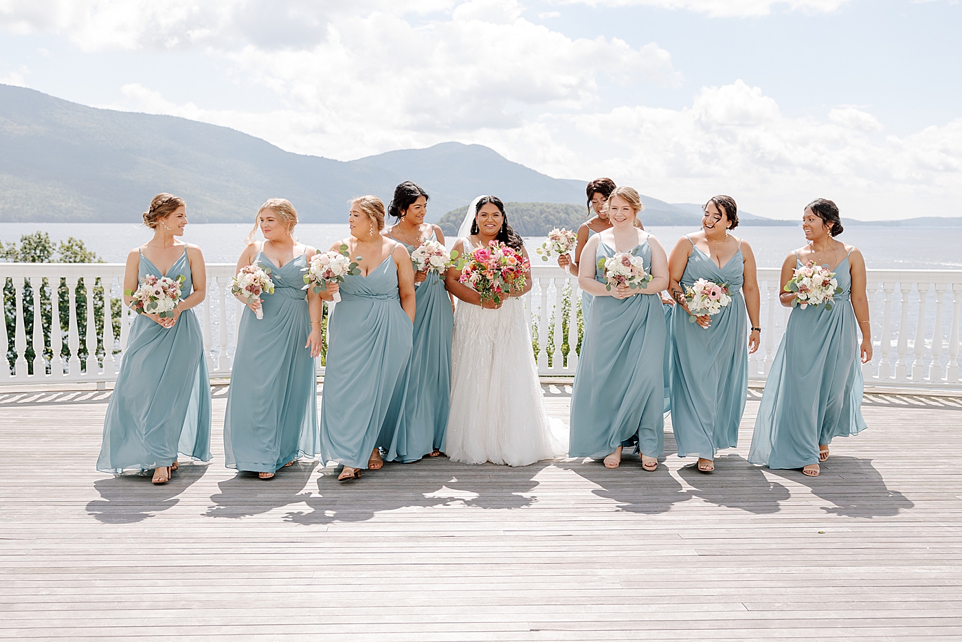 Informal portraits of a bride and her bridesmaids in blue walking towards the camera | Image by Hope Helmuth Photography