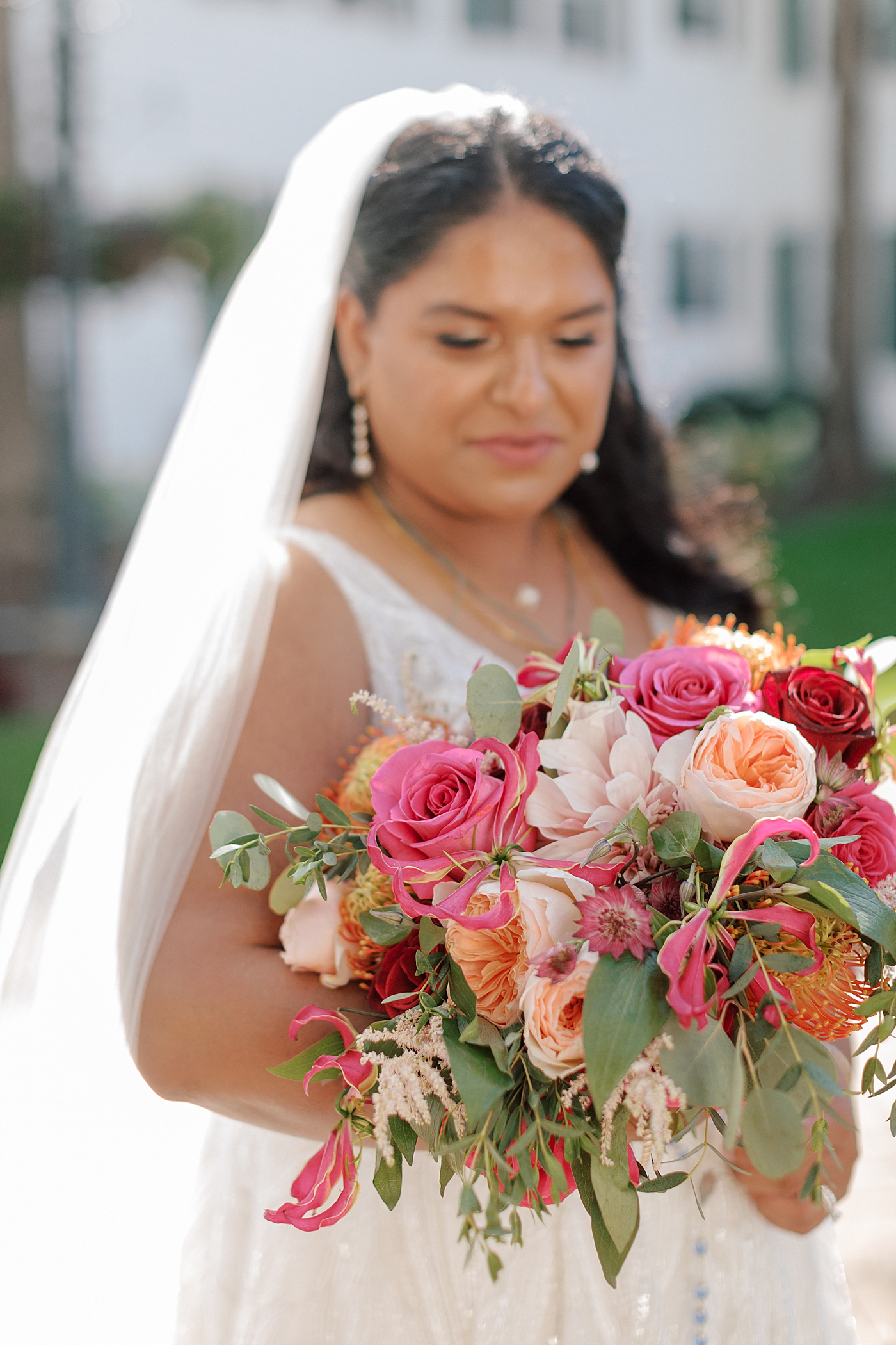 Close up image of a bride with her colorful bridal bouquet | Image by Hope Helmuth Photography