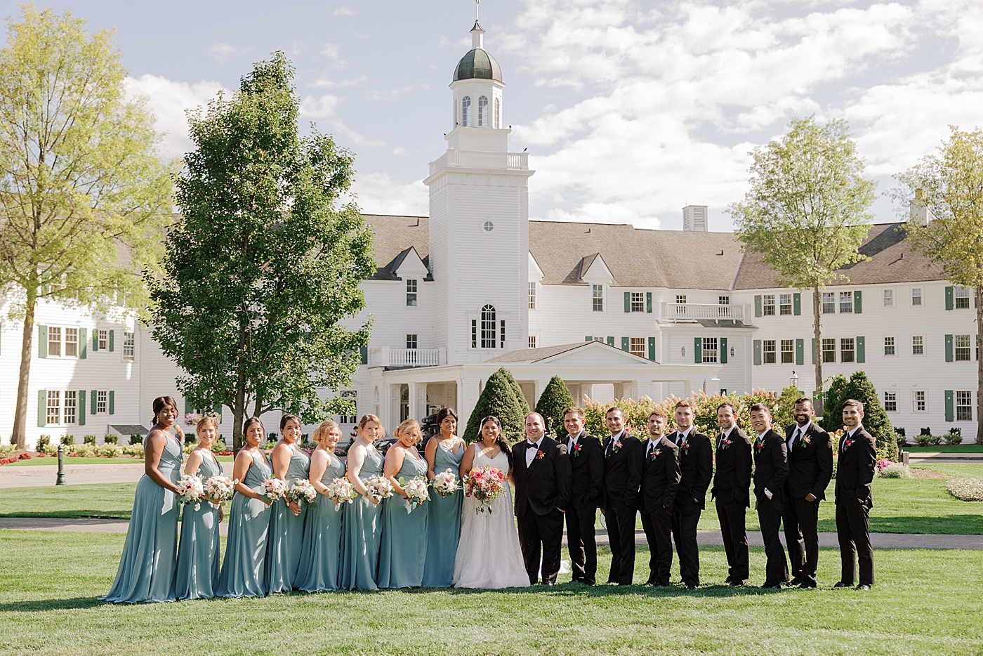Formal image of the entire wedding party in front of the venue | Image by Hope Helmuth Photography