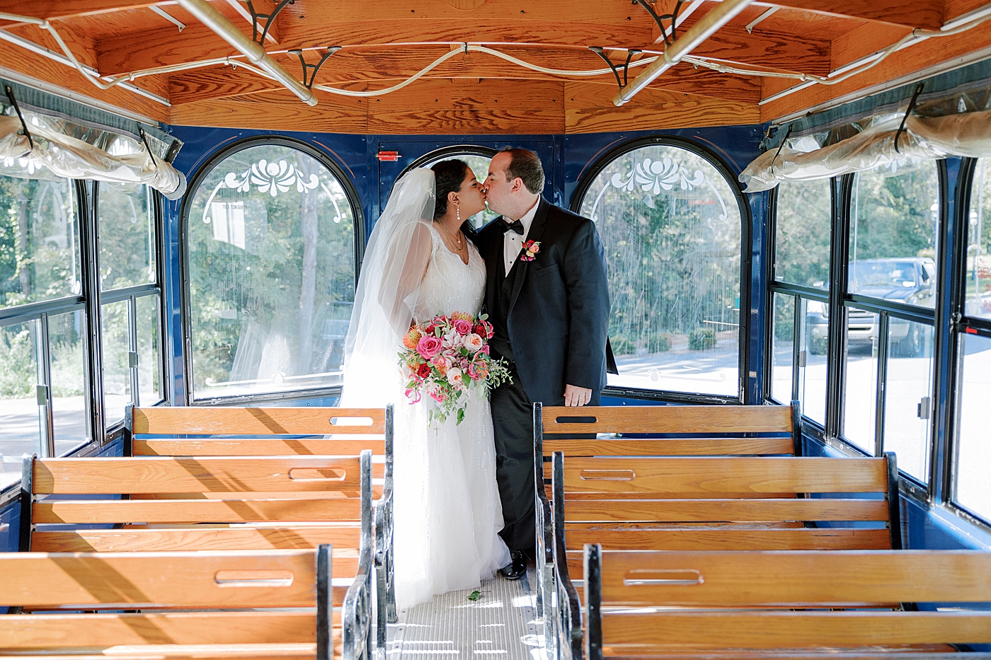 Bride and groom kissing in the back of a trolley | Image by Hope Helmuth Photography