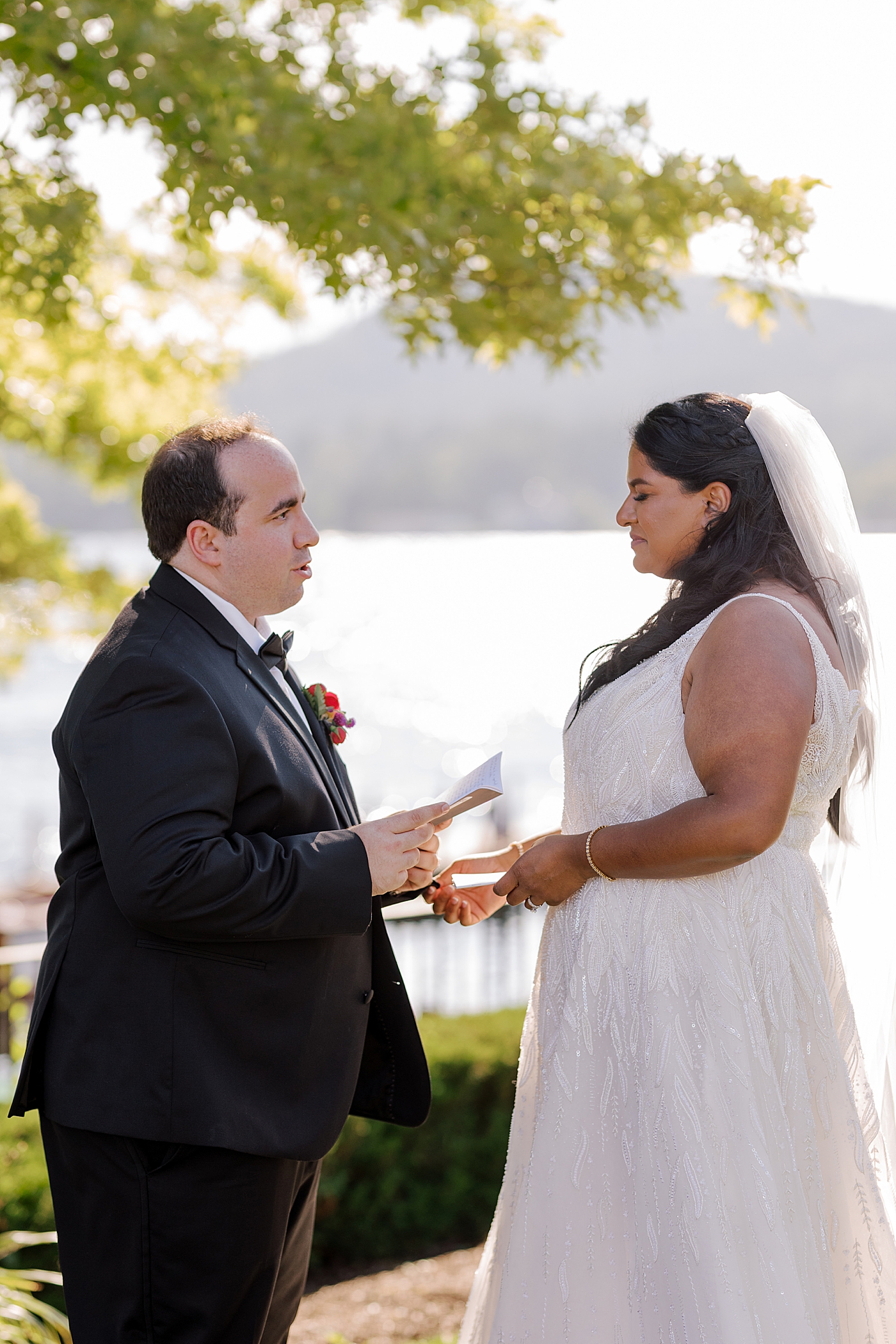 Image of bride and groom reading vows to each other | Image by Hope Helmuth Photography