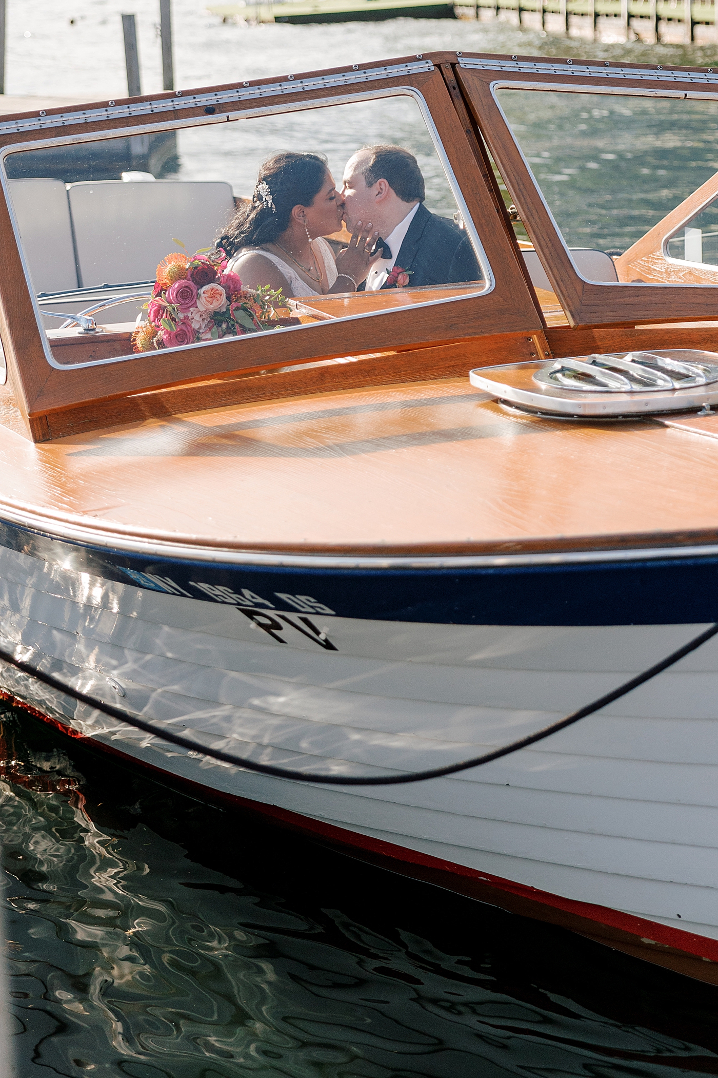 Bride and groom kissing on a wooden boat | Image by Hope Helmuth Photography
