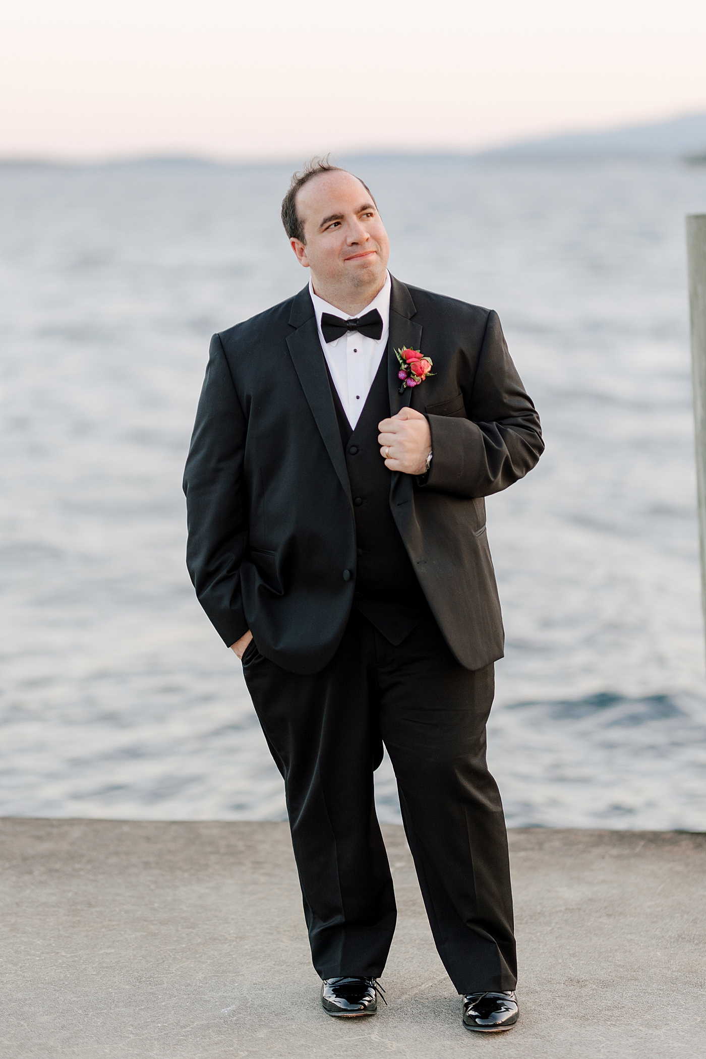 Groom posing, smiling on a dock at sunset during Sagamore Wedding | Image by Hope Helmuth Photography