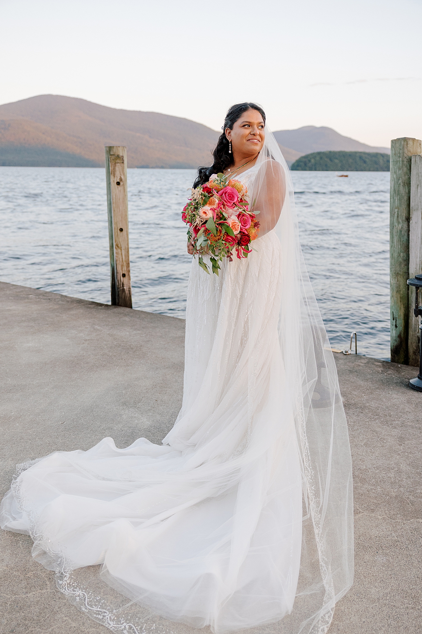 Bride posing, smiling on a dock at sunset during their Sagamore Wedding | Image by Hope Helmuth Photography