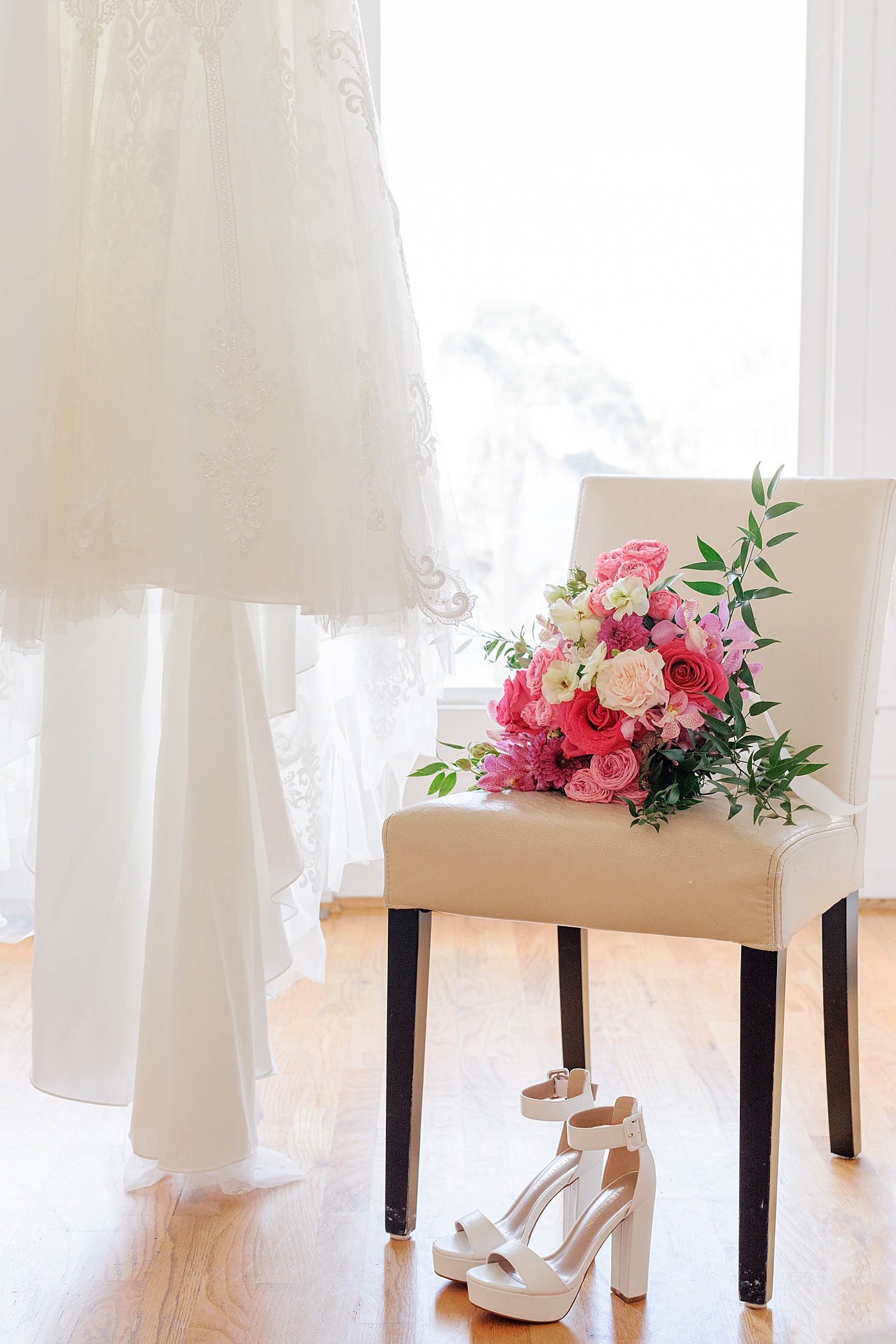 Wedding details of a bouquet on a chair, wedding shoes, and a wedding dress | Image by Hope Helmuth Photography