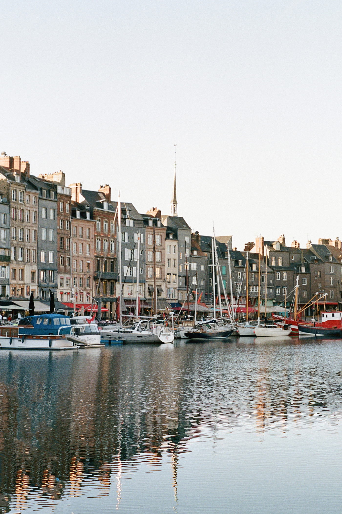 Tall, multistory homes and docked sailboats on the opposite side of a French canal | Image by Hope Helmuth Photography