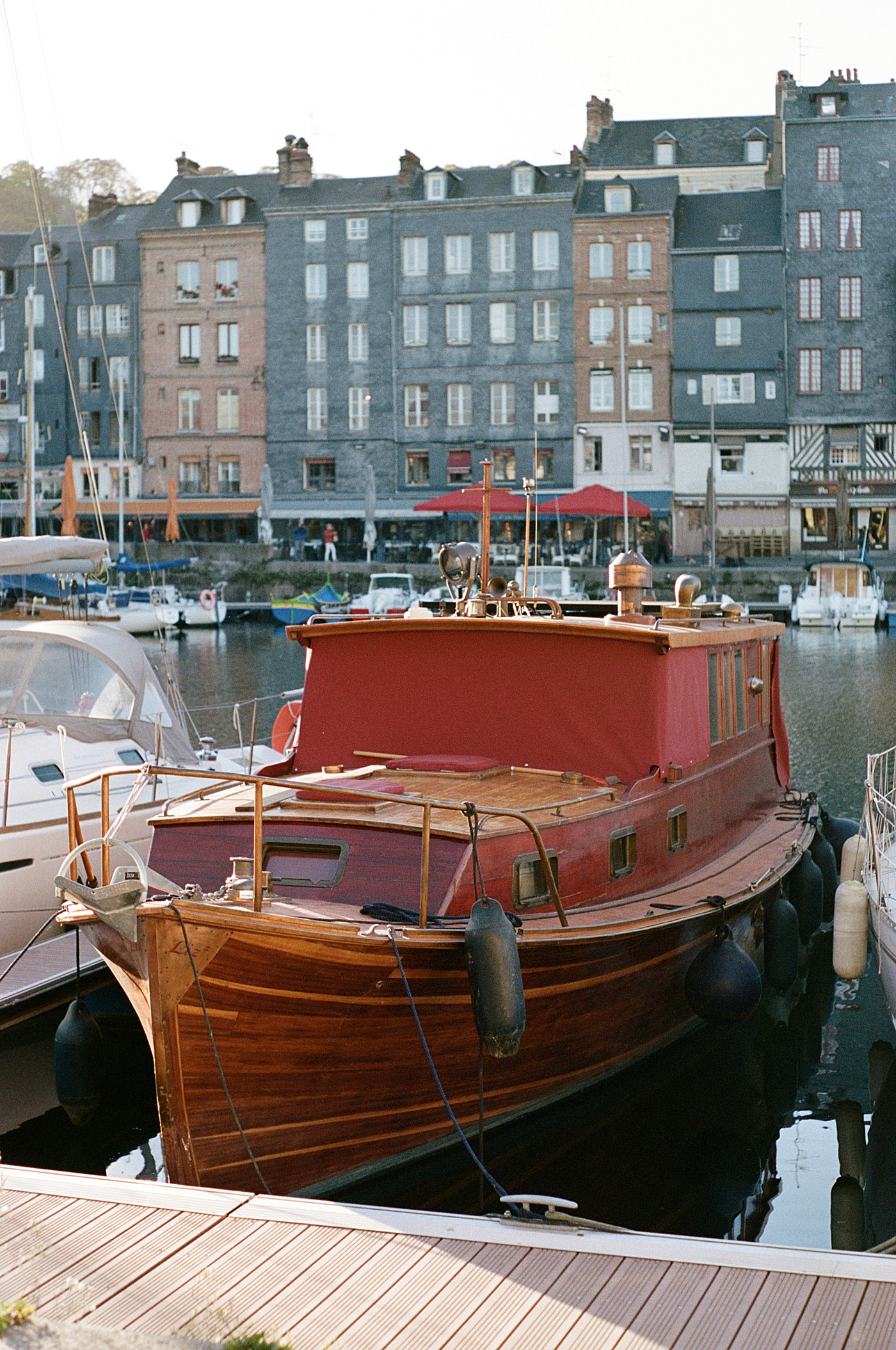 Docked boat in a French canal with tall, multistory homes in the background during a trip with France Wedding Photographer Hope Helmuth Photography