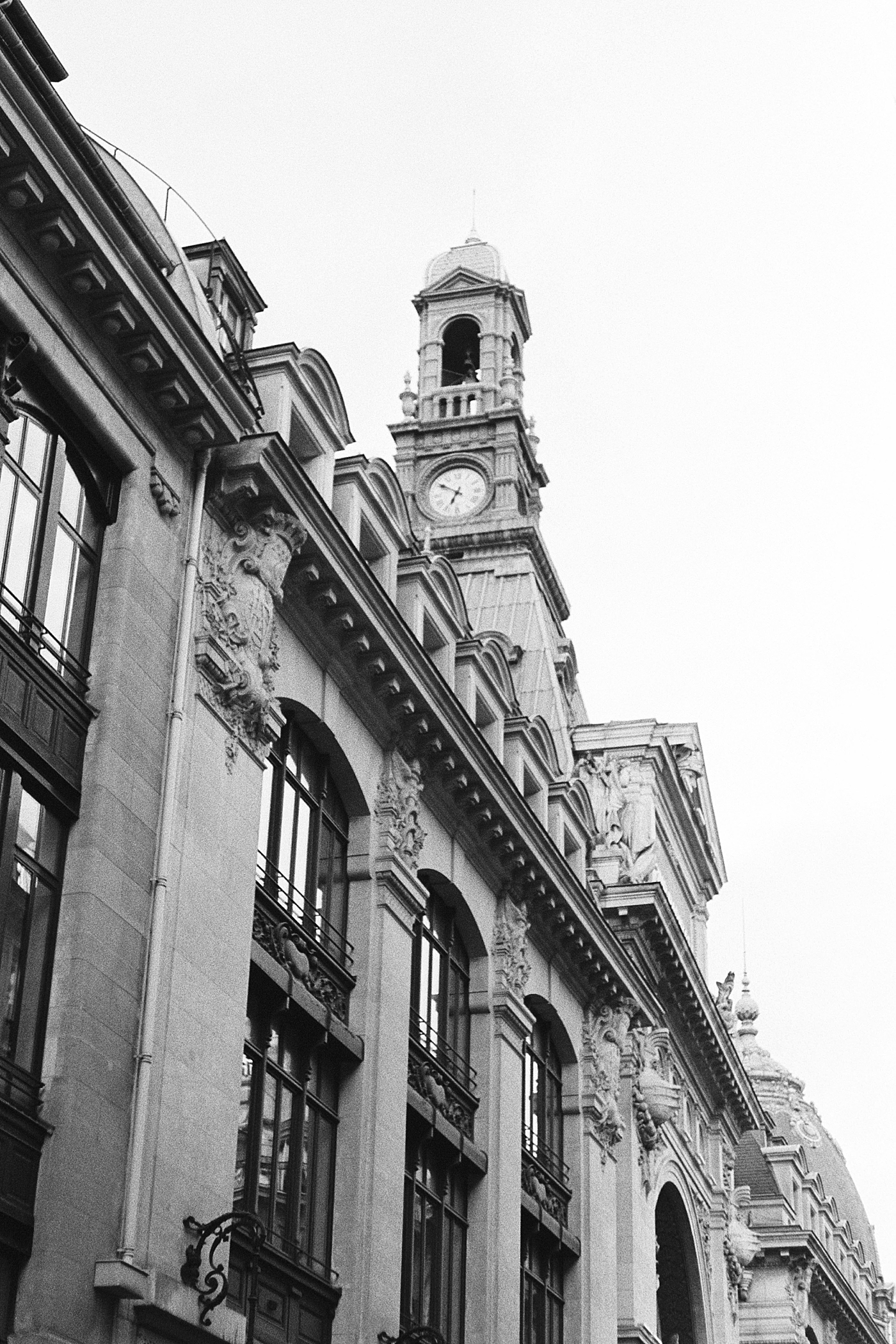 Black and white image looking up at the top of an ornate building from the street during a trip with France Wedding Photographer Hope Helmuth Photography