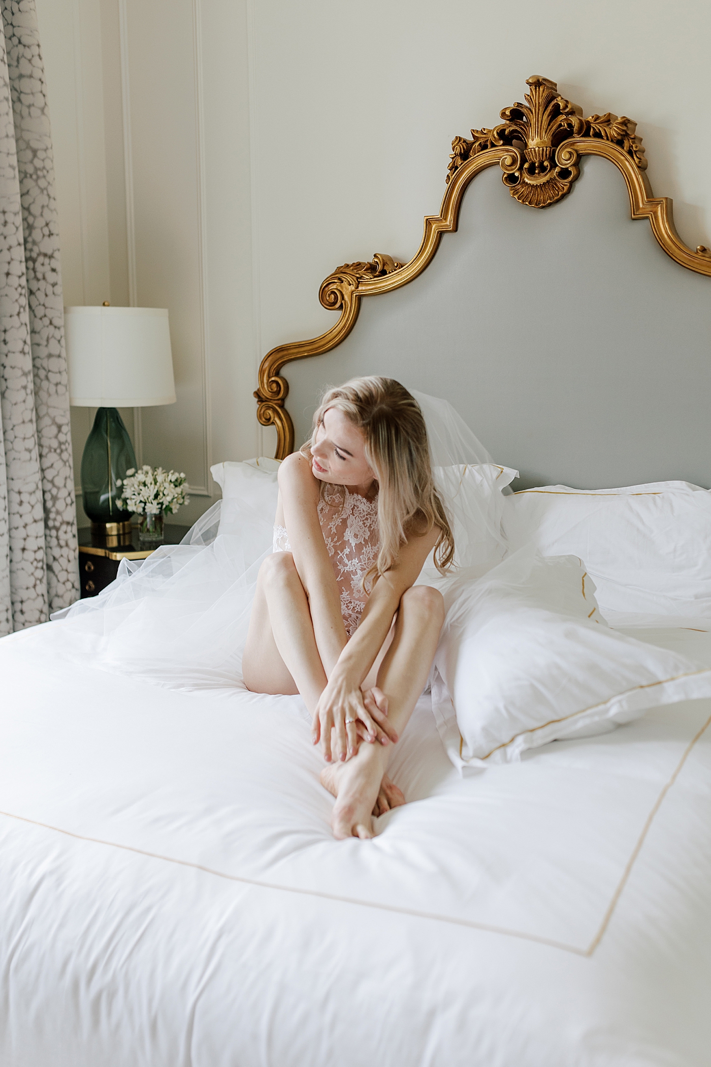 Bride-to-be posing in white lingerie on a romantic, luxe white bed | Image by Hope Helmuth Photography