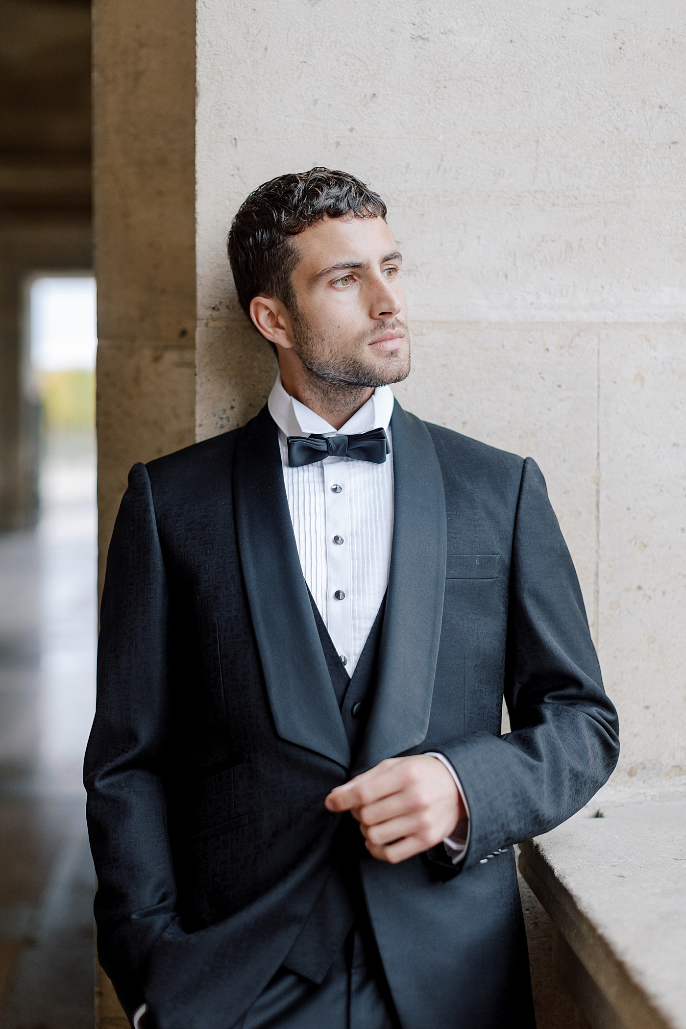 Close up of a groom in a tuxedo and bowtie looking away from the camera during a Paris Elopement | Image by Hope Helmuth Photography