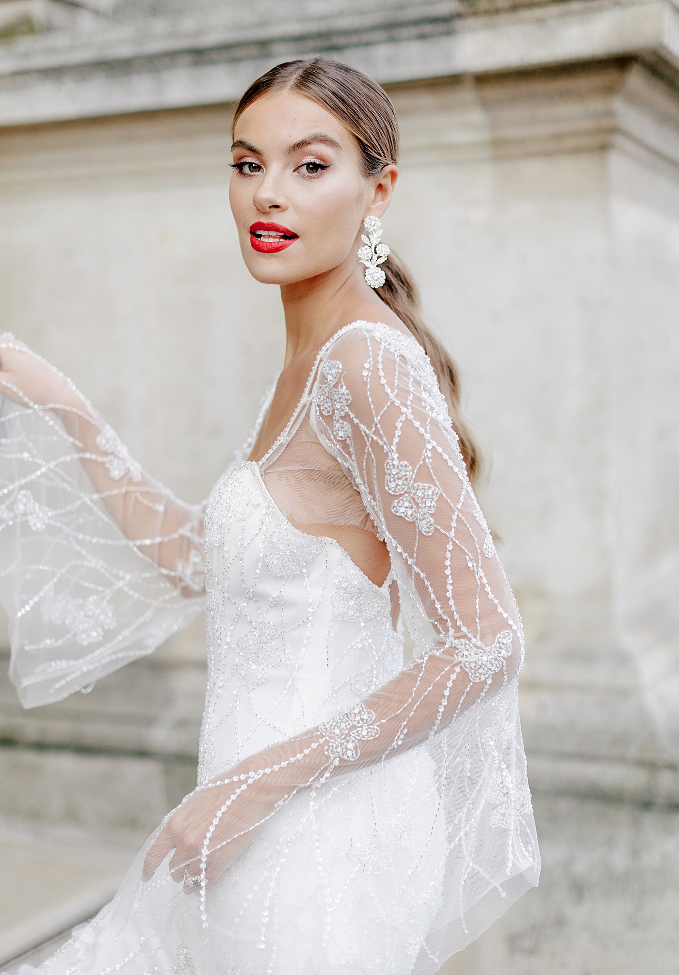 Close up image of a bride in a white dress with bride red lipstick during a Paris Elopement | Image by Hope Helmuth Photography
