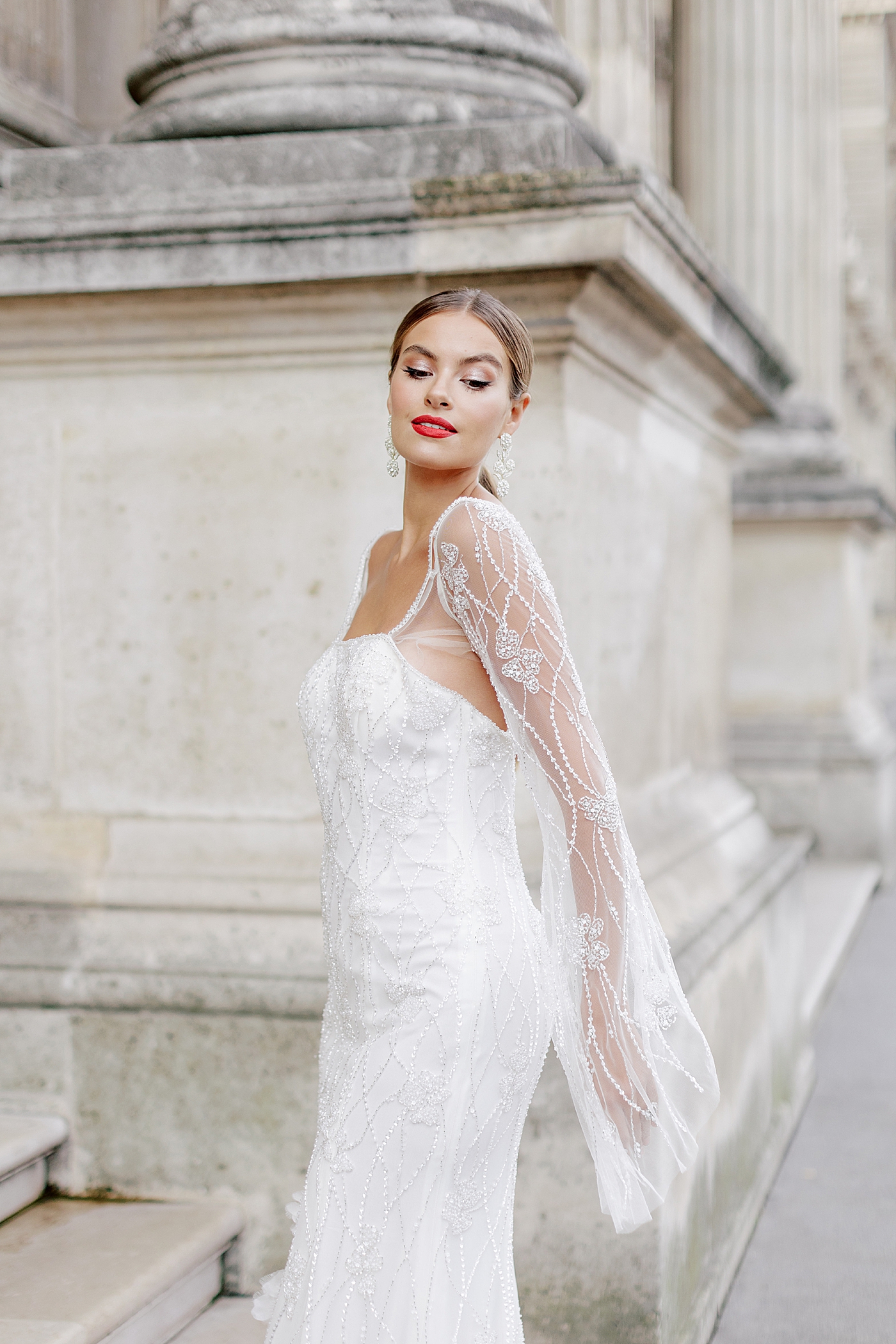 Close up of a bride in a white dress with bright red lipstick during a Paris Elopement | Image by Hope Helmuth Photography