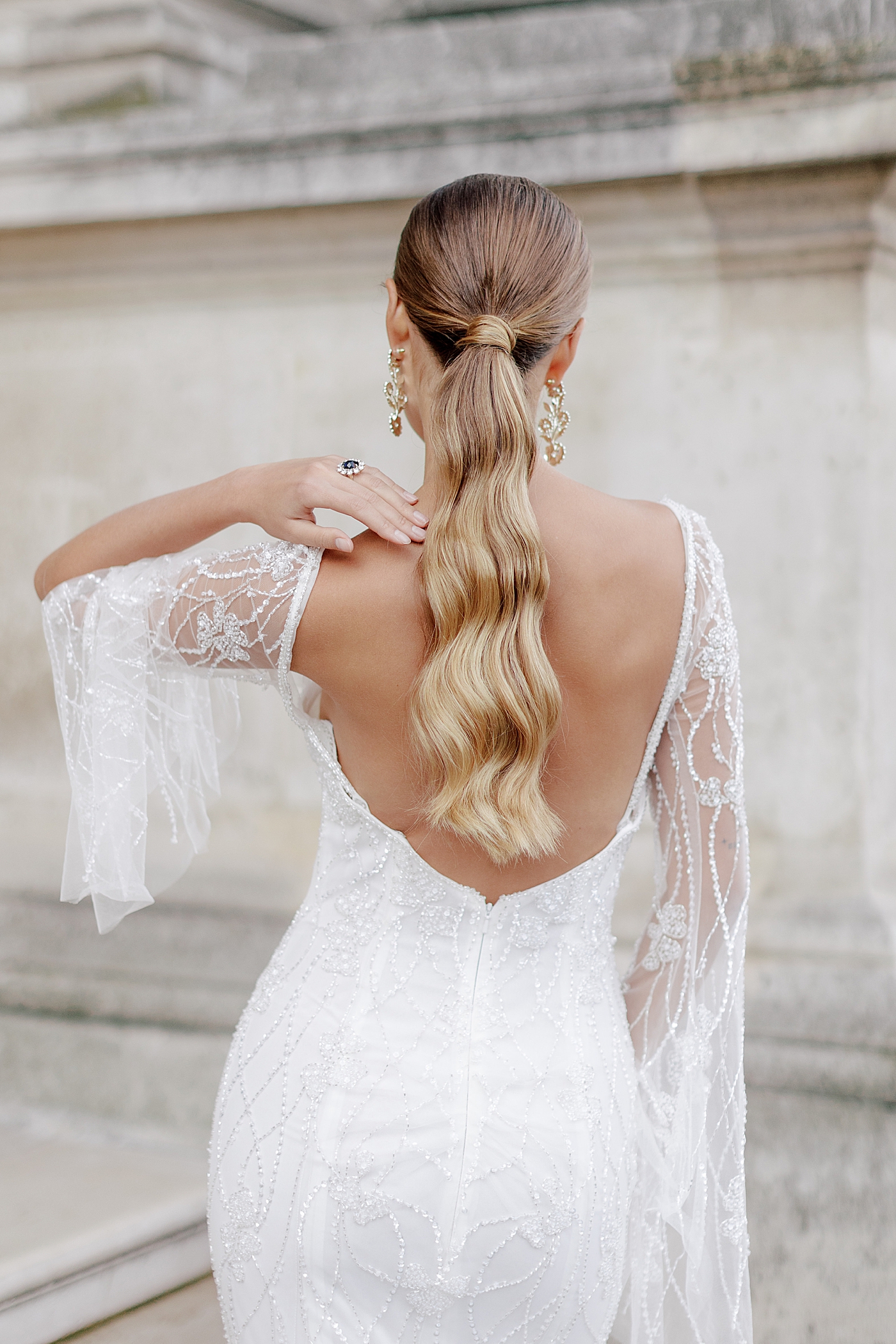 Back of dress and hair details of a bride with a ponytail | Image by Hope Helmuth Photography