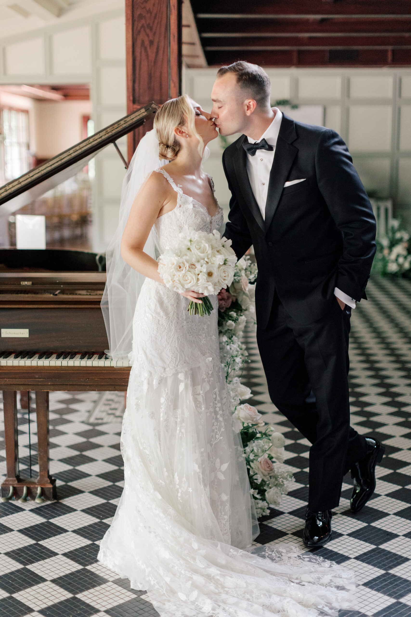 Couple kissing in front of a piano at Hotel du Village | Image by Hope Helmuth