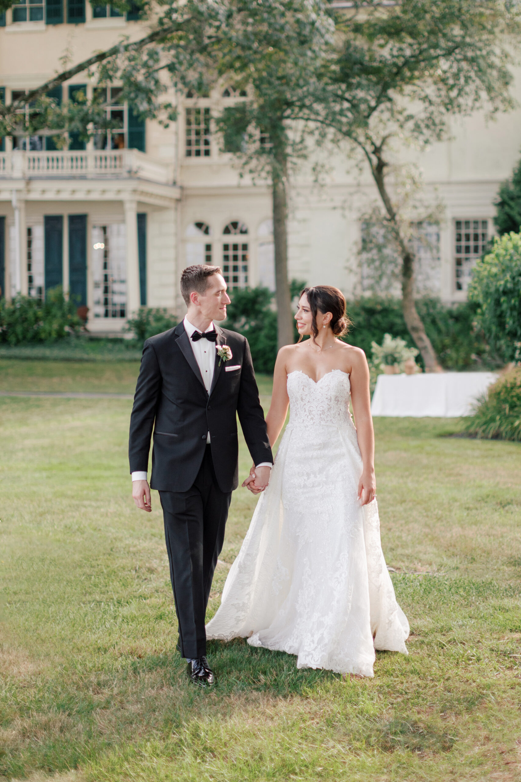 Bride and groom walking hand in hand in front of their wedding venue | Image by Hope Helmuth