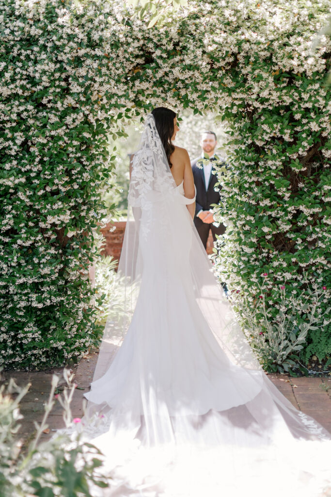 Bride walking through the gardens at Tryon Palace in her classic gown during a North Carolina wedding