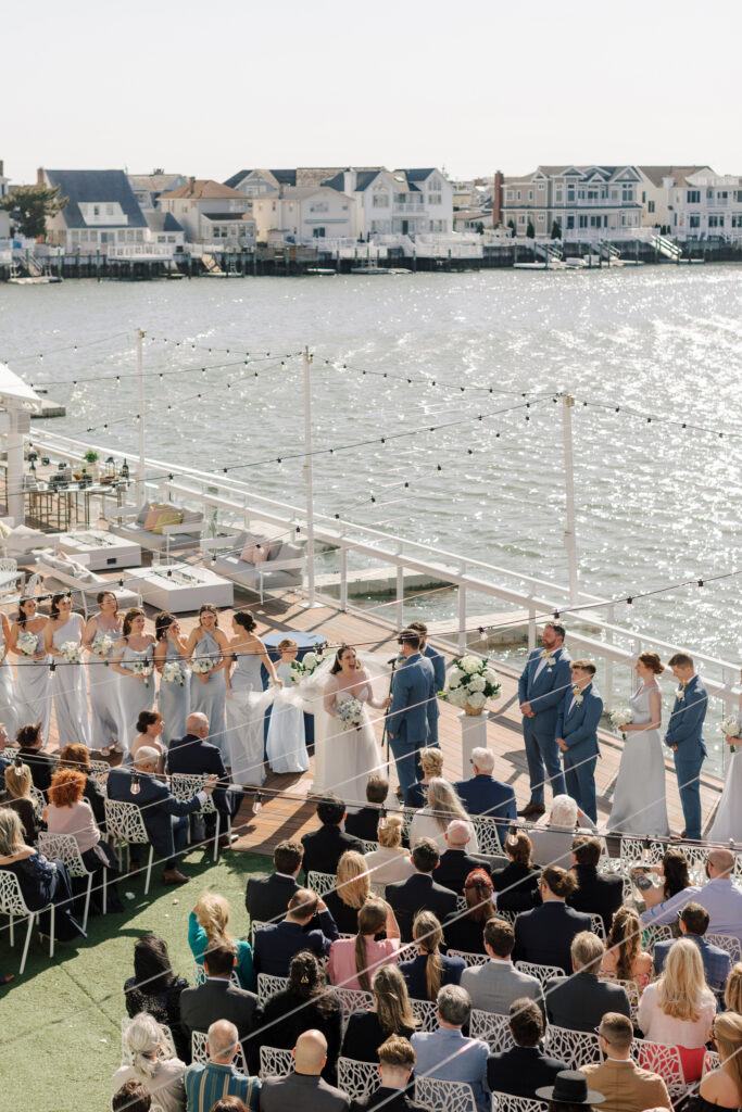 The Reeds at Shelter Haven wedding ceremony with white hydrangeas on the bay in Stone Harbor