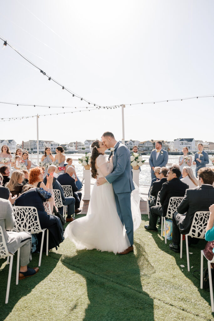 Bride and groom embracing by the water at a Stone Harbor wedding venue, The Reeds at Shelter Haven
