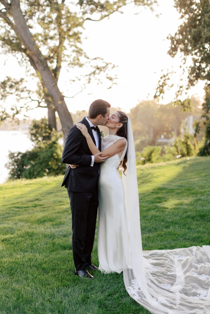 coastal-waterfront-tented-wedding-photos-45 Bride in a Danielle Frankel gown with lace veil walking along the waterfront at a private estate tented wedding.